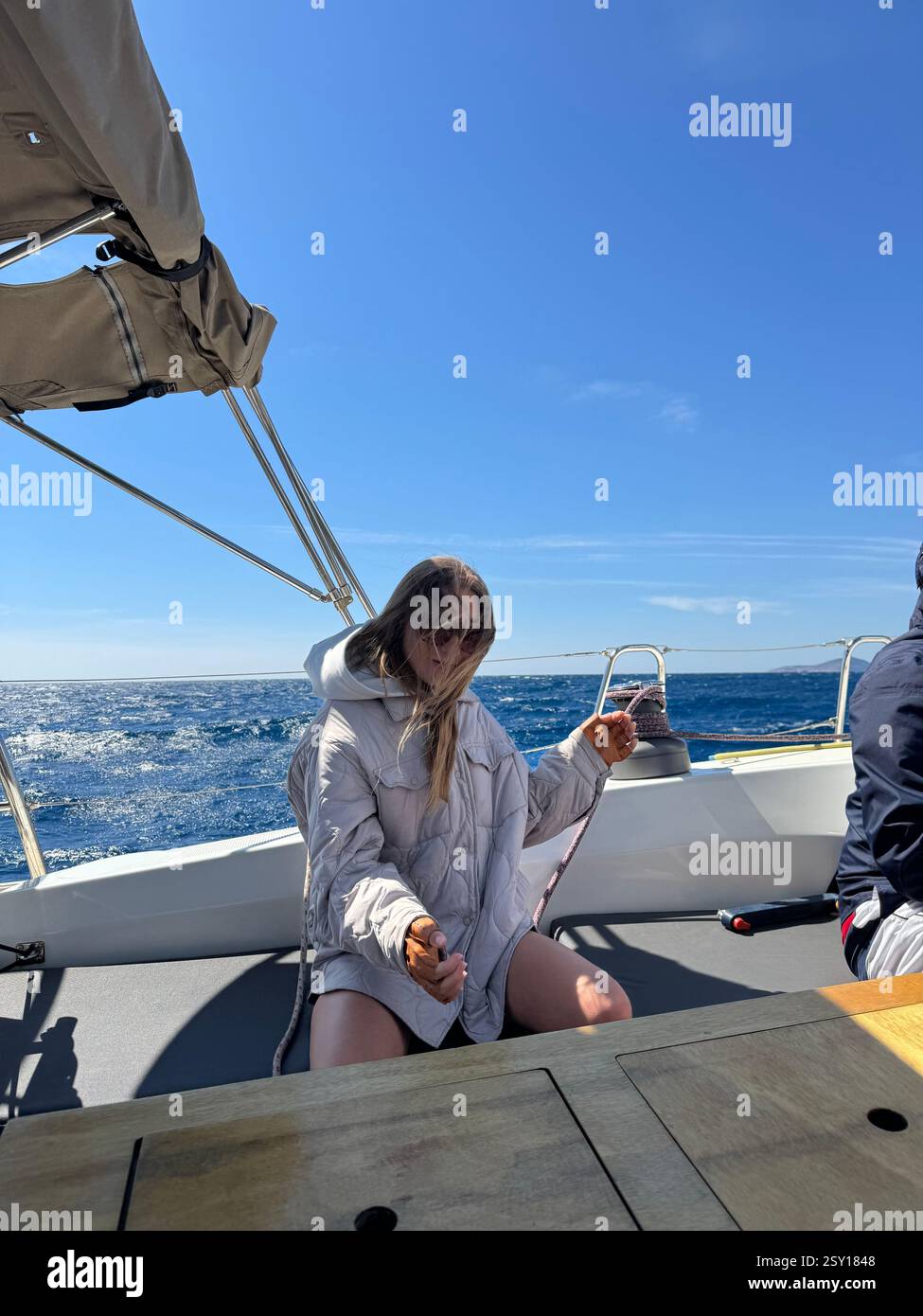Jeune femme profitant d'une journée ensoleillée naviguant sur un bateau dans l'océan Banque D'Images