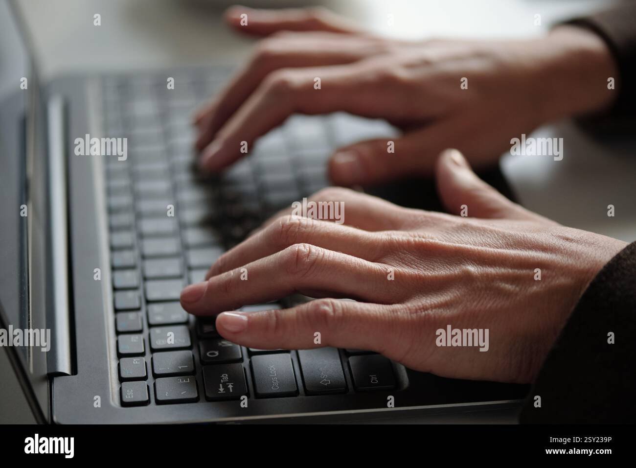 Mains féminines tapant sur le clavier d'ordinateur portable travaillant via Internet Skin texture Neat Manicure Banque D'Images