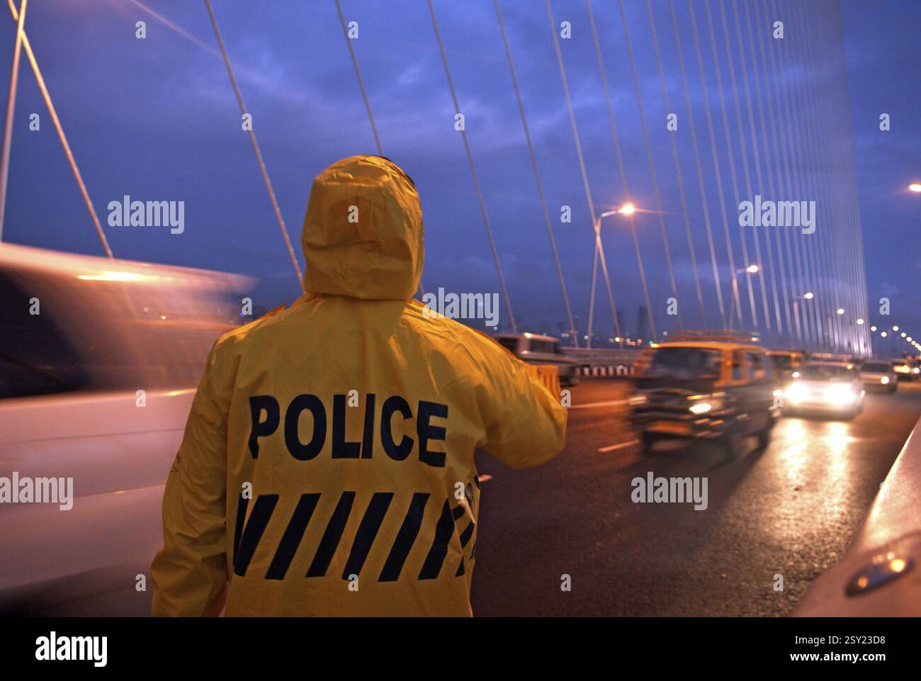 Trafic policier en imperméable guidant le trafic sur bandra worli rajiv gandhi liaison maritime, Bombay Mumbai, Maharashtra, Inde, Asie Banque D'Images