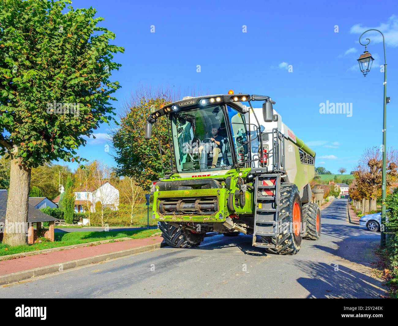 Moissonneuse-batteuse CLAAS Lexion 6700 conduite dans le village - Bossay-sur-Claise, Indre-et-Loire (37), France. Banque D'Images
