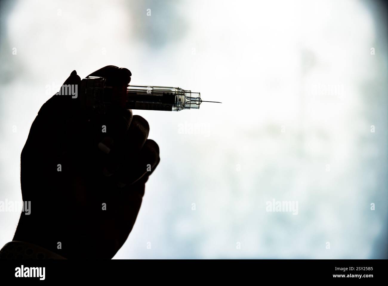 Main de femme dans l'ombre avec injection préparée pour l'application Banque D'Images