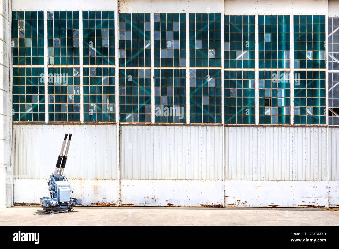 Bâtiment blanc avec une fenêtre bleue. Un robot se tient devant le bâtiment. Le robot est blanc et a une tête bleue Banque D'Images