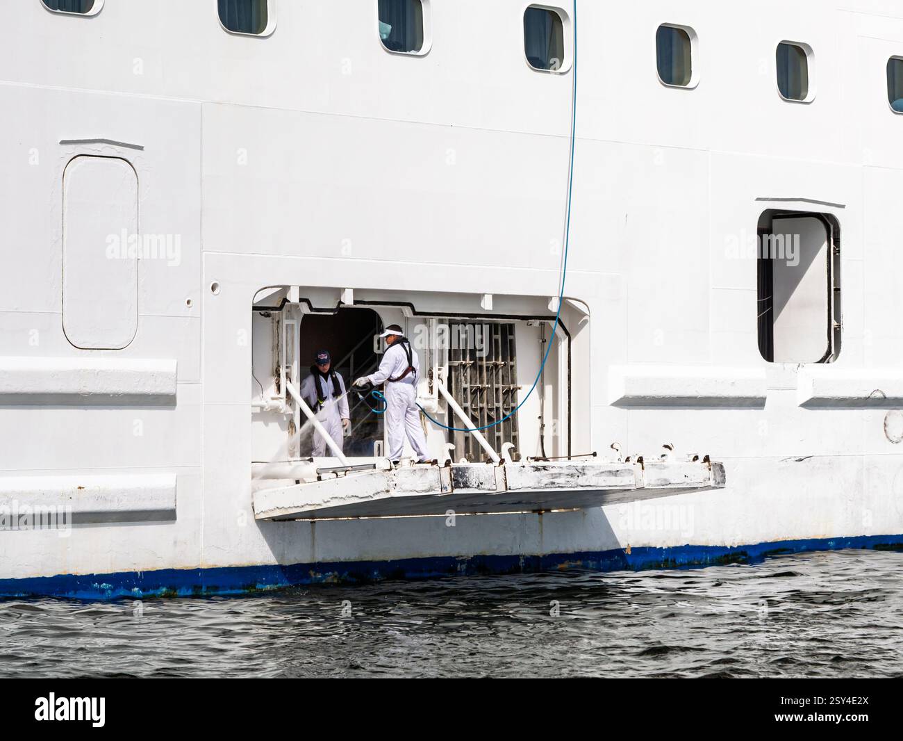 Les membres d'équipage lavent le ferry-boat sous pression de la rampe ouverte dans le port, entretien maritime avec nettoyeur haute pression Banque D'Images