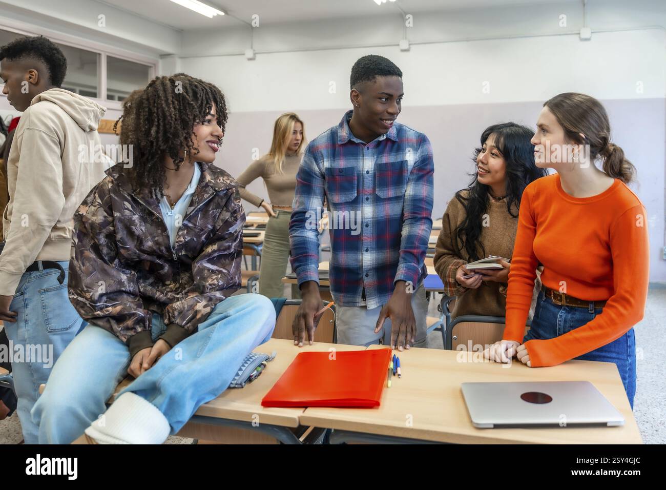 Groupe diversifié d'étudiants universitaires s'engageant dans le travail d'équipe, discutant d'idées et travaillant ensemble sur un projet dans un cadre de classe Banque D'Images