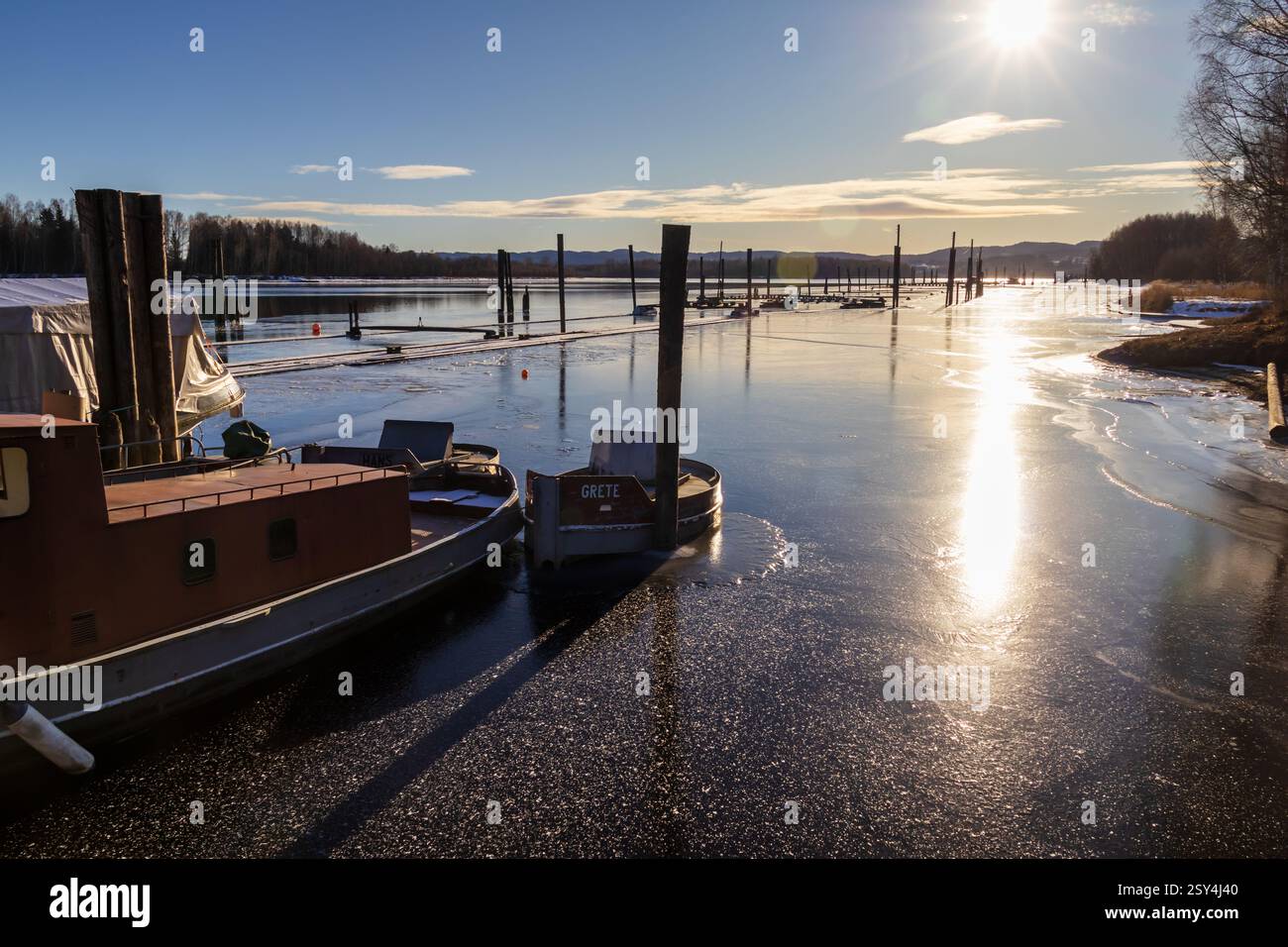 Gelés dans le temps, les bateaux métalliques reposent enveloppés dans la glace, travaillant autrefois les eaux de Fetsund Lenser, reflétant maintenant la lumière de l’hiver Banque D'Images