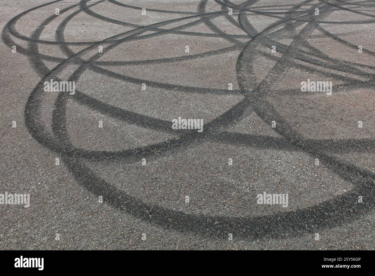 Gros plan des traces de pneus en caoutchouc brûlés sur l'asphalte. Banque D'Images