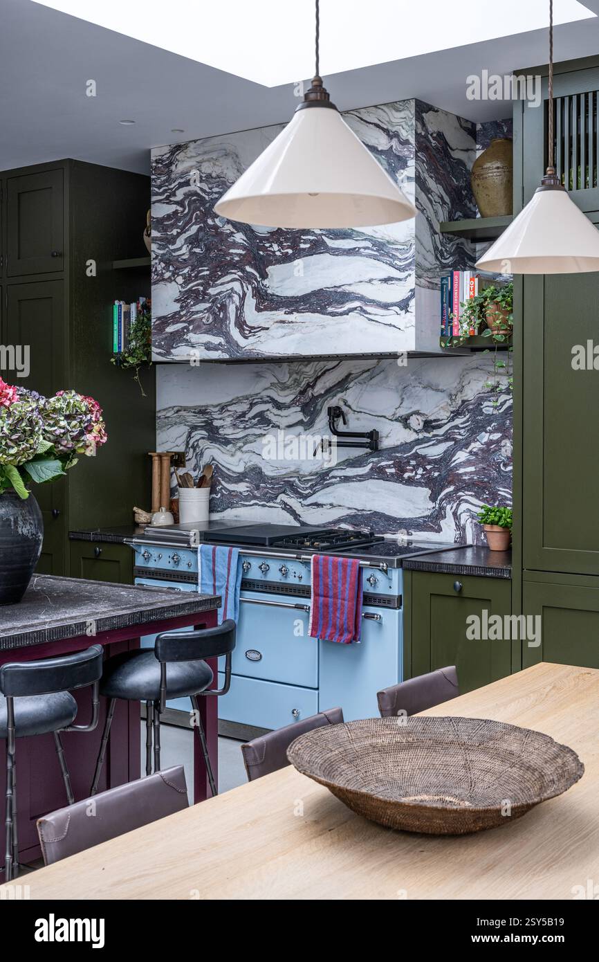 Suspensions au-dessus de la table avec peinture aubergine et vert olive dans une refonte contemporaine de la maison de l'ouest de Londres. Banque D'Images
