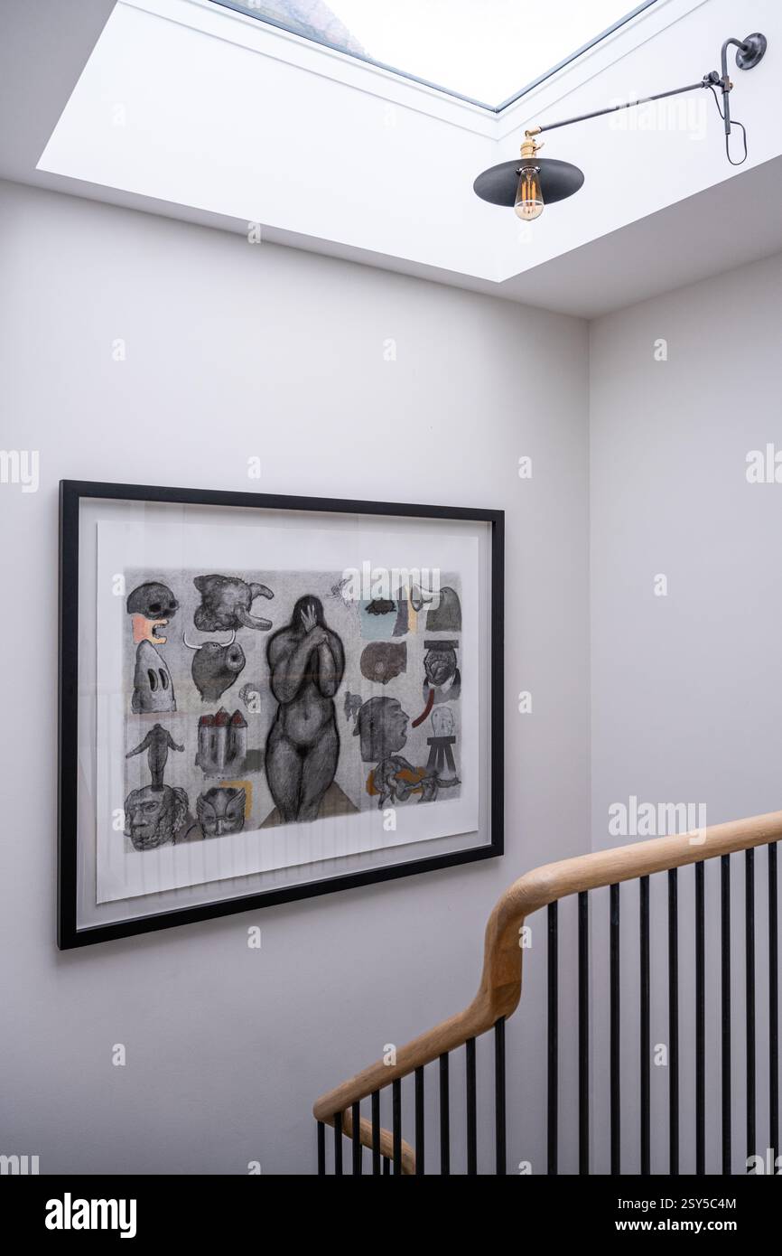 Œuvres d'art surréalistes et puits de lumière dans l'escalier de la maison redessinée de l'ouest de Londres. Banque D'Images