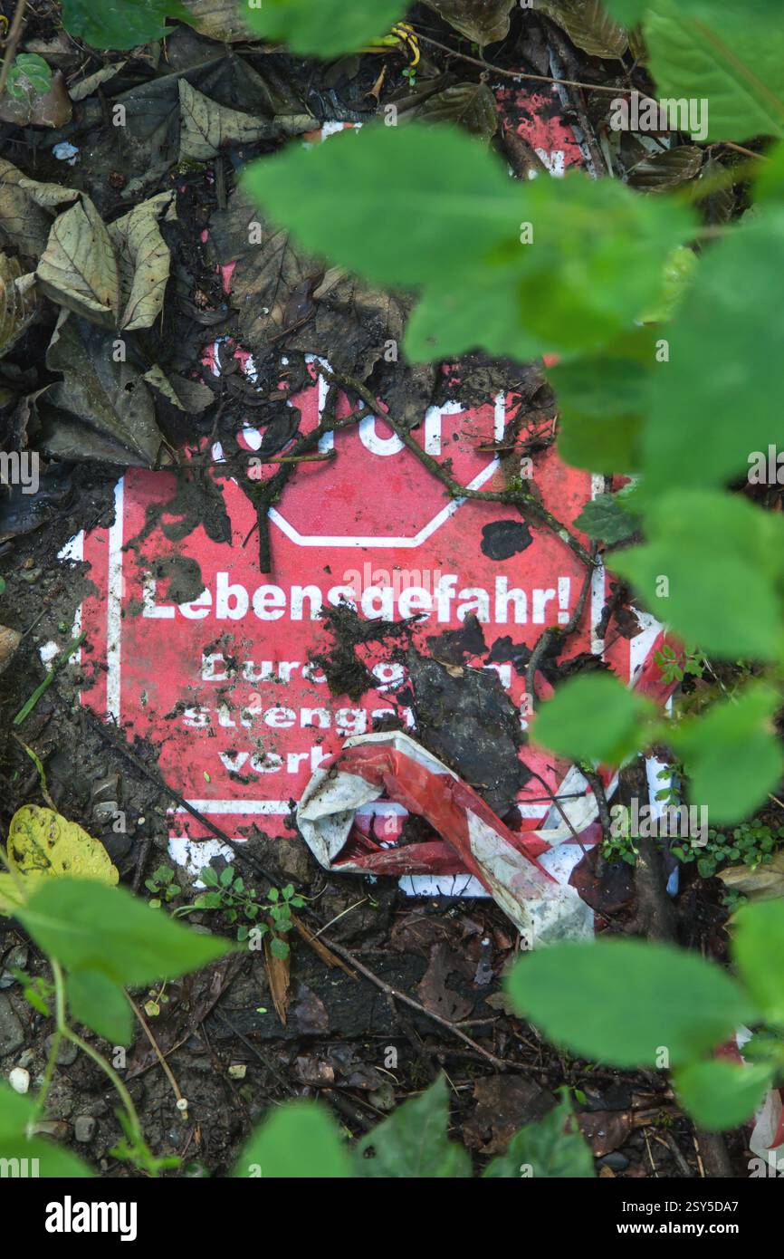 Panneau envahi par la végétation avec l'inscription danger pour la vie, passage strictement interdit, Allemagne Banque D'Images
