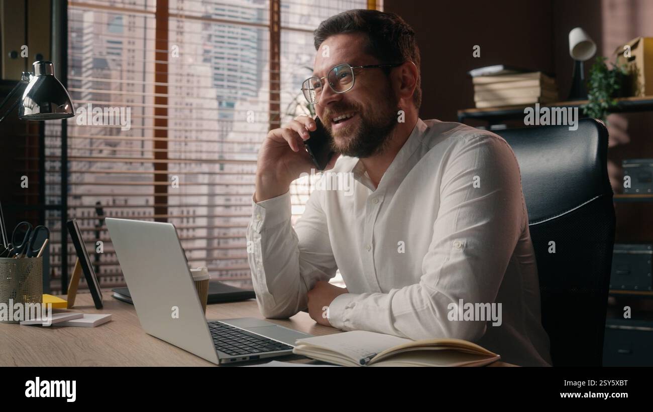 Heureux souriant homme d'affaires caucasien entrepreneur homme agent travailleur parlant téléphone mobile homme exécutif appel exécutif dans la société de bureau gars montrant pouce vers le haut Banque D'Images