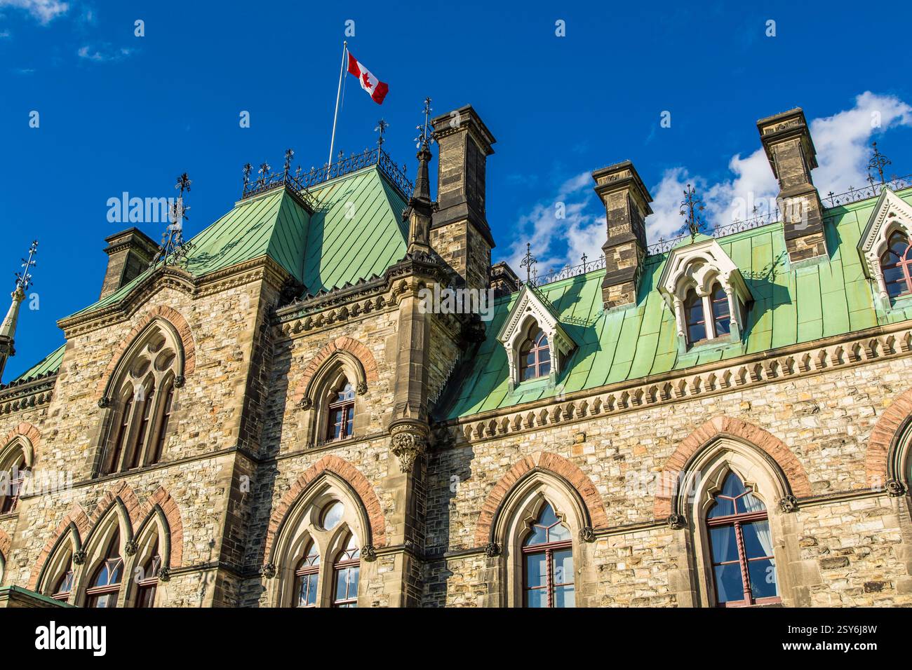 Bâtiment avec un toit vert et un drapeau sur le dessus. Le bâtiment a beaucoup de fenêtres Banque D'Images