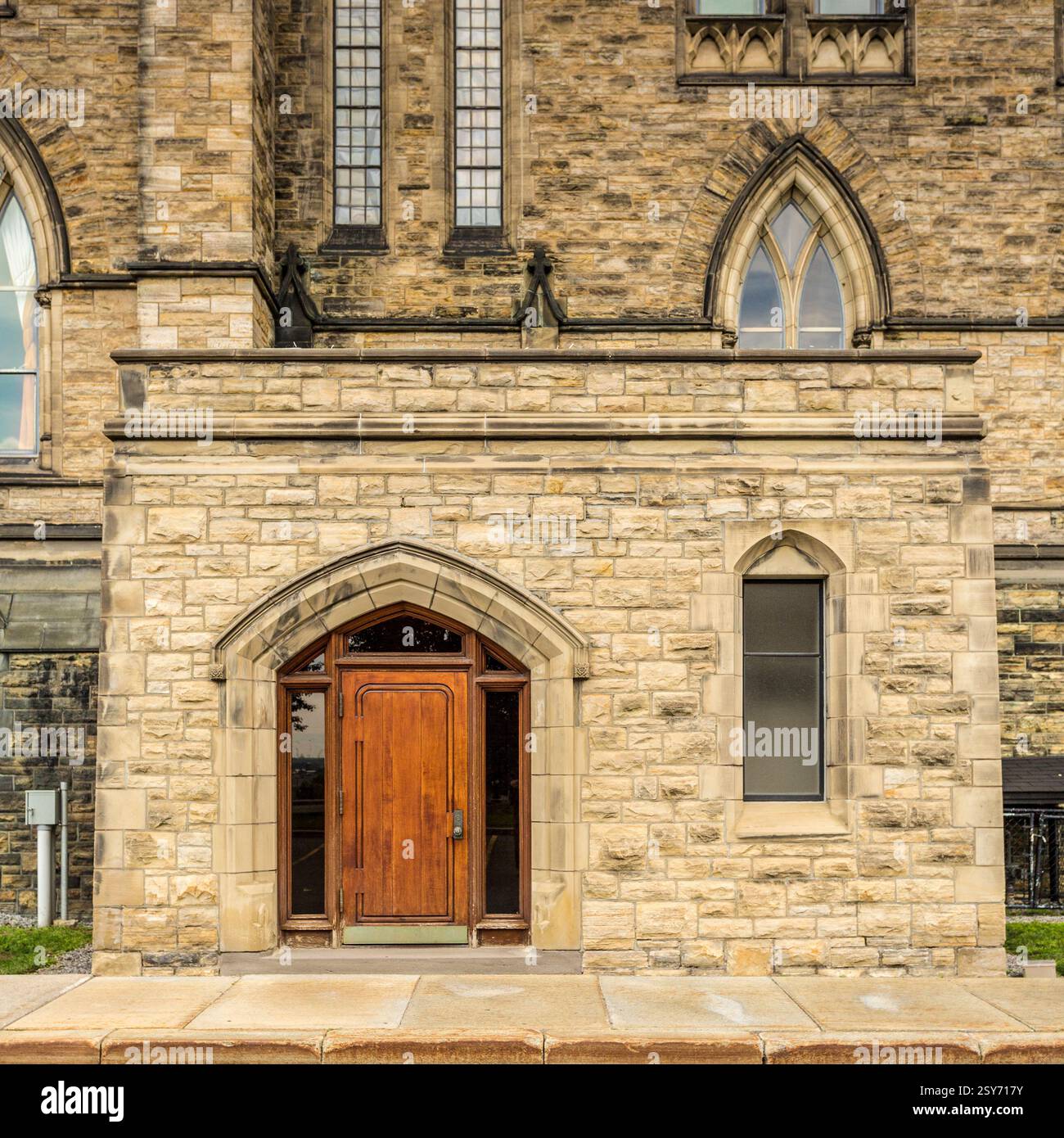 Bâtiment en brique avec une porte en bois. La porte est brune et a un cadre en bois. Le bâtiment a une arche en pierre Banque D'Images