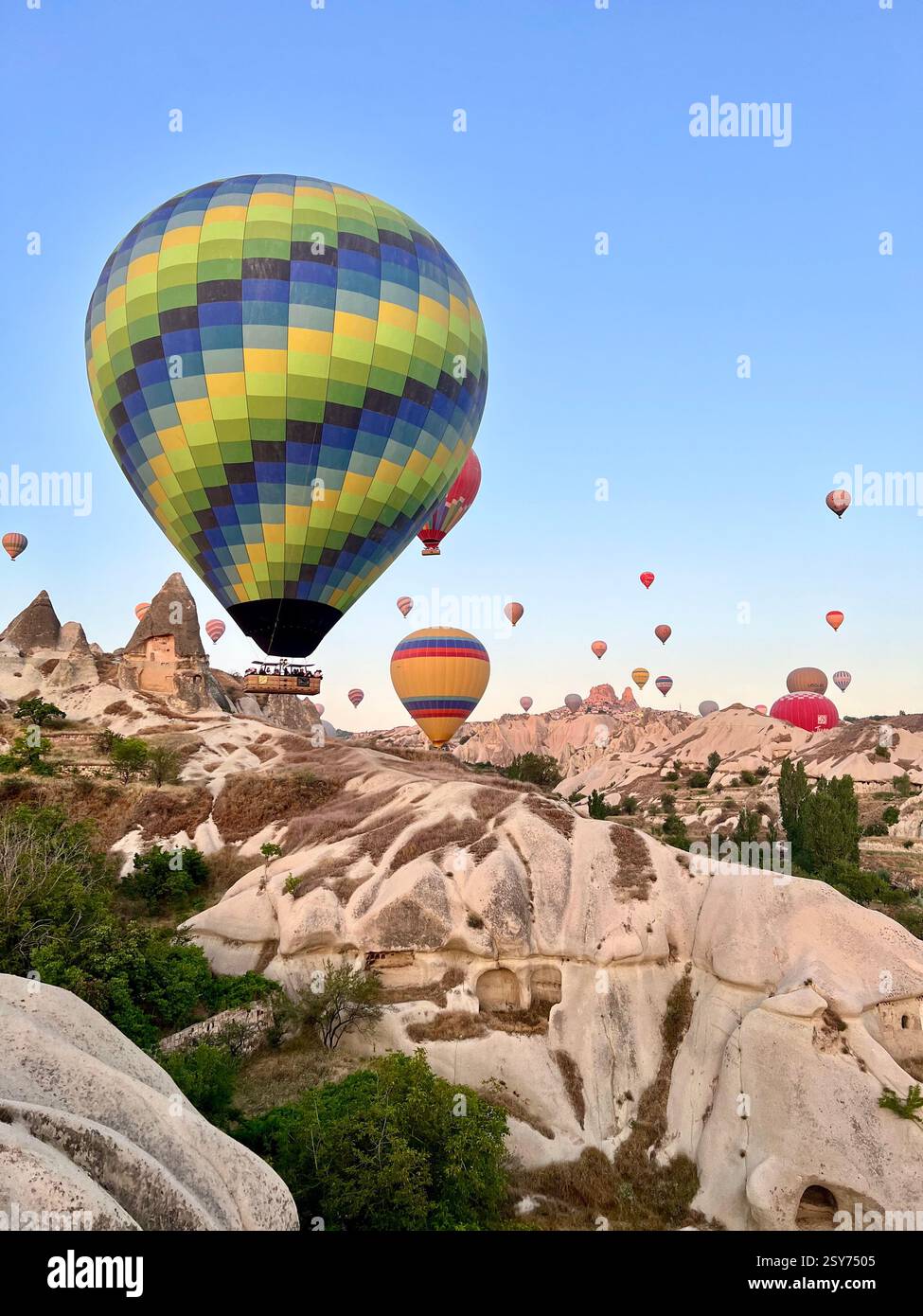 Montgolfières colorées flottant au-dessus des formations rocheuses uniques de Cappadoce, Turquie - Image de stock capturée avec un smartphone