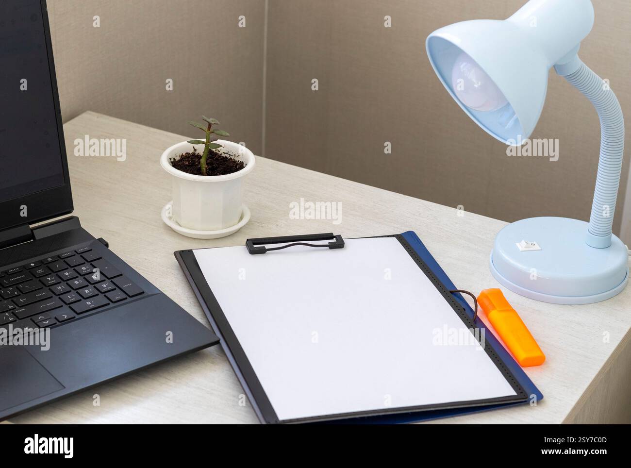 Photo de la chemise en plastique sur le bureau avec support trombone sur le dessus et d'autres articles de bureau. Maquette de papier au format A4. Banque D'Images