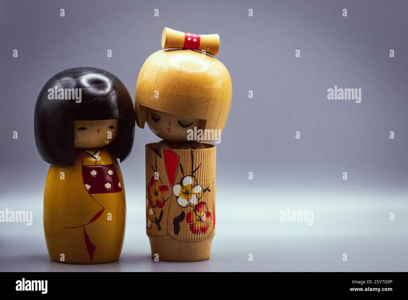 Poupées Kokeshi, isolées sur un fond gris Banque D'Images