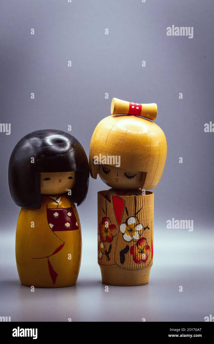 Poupées Kokeshi, isolées sur un fond gris Banque D'Images