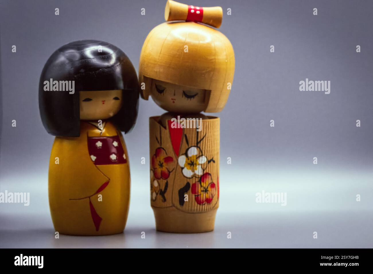 Poupées Kokeshi, isolées sur un fond gris Banque D'Images