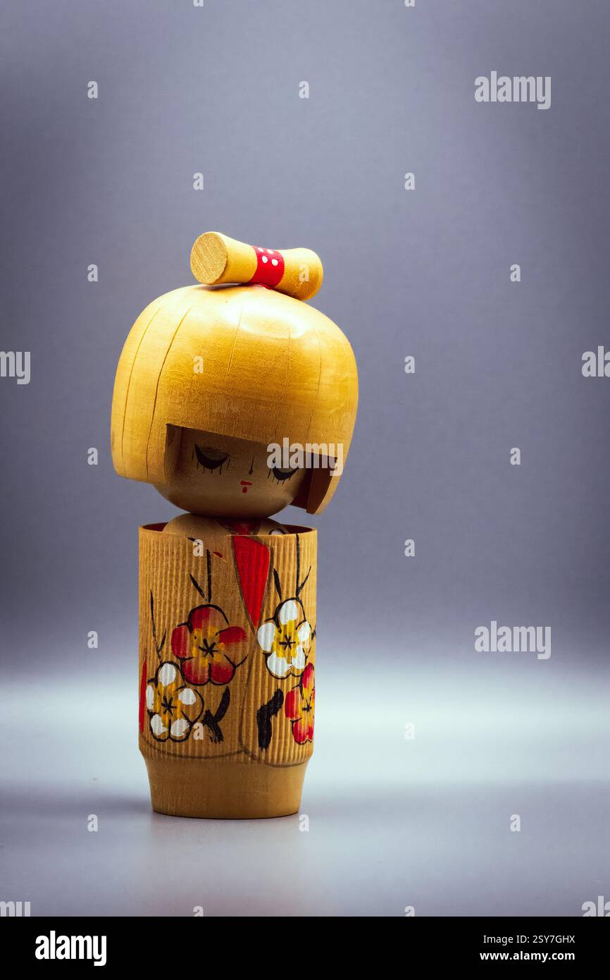 Poupées Kokeshi, isolées sur un fond gris Banque D'Images