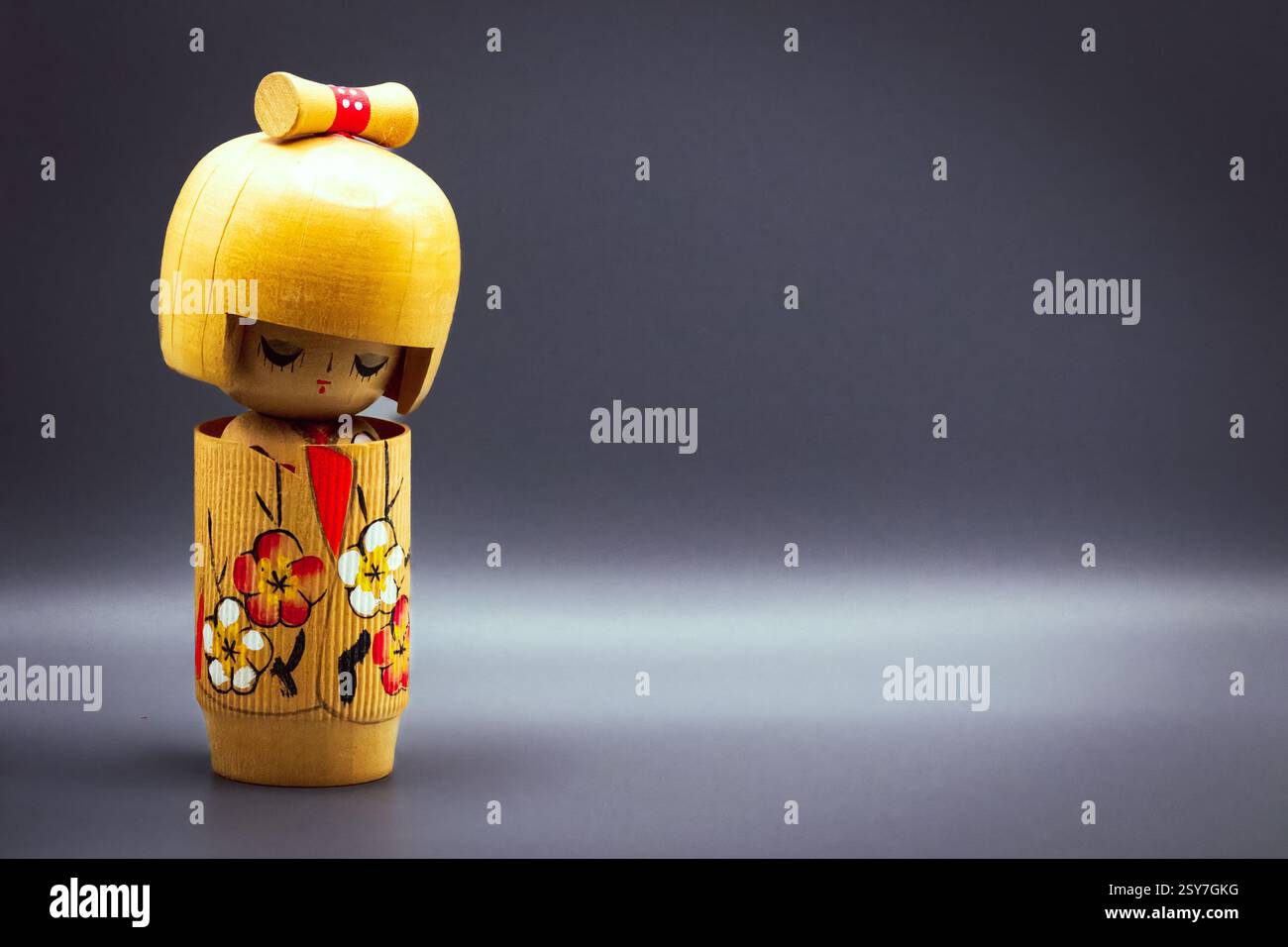 Poupées Kokeshi, isolées sur un fond gris Banque D'Images