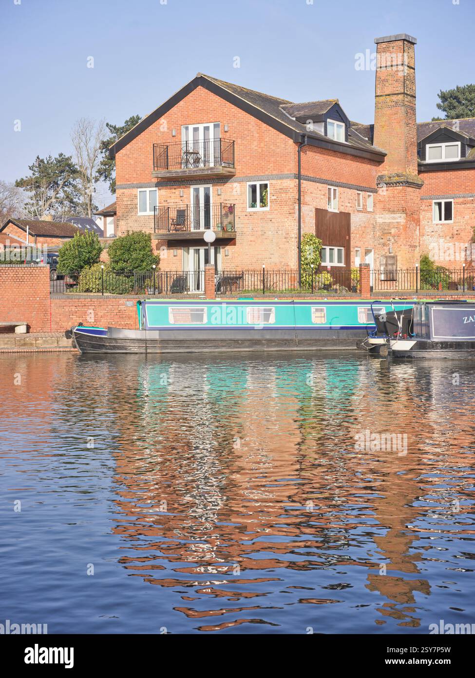 Bateau de canal amarré dans la marina Union Wharf, Grand Union canal, Market Harborough, Angleterre, à côté d'anciens entrepôts, maintenant appartements. Banque D'Images