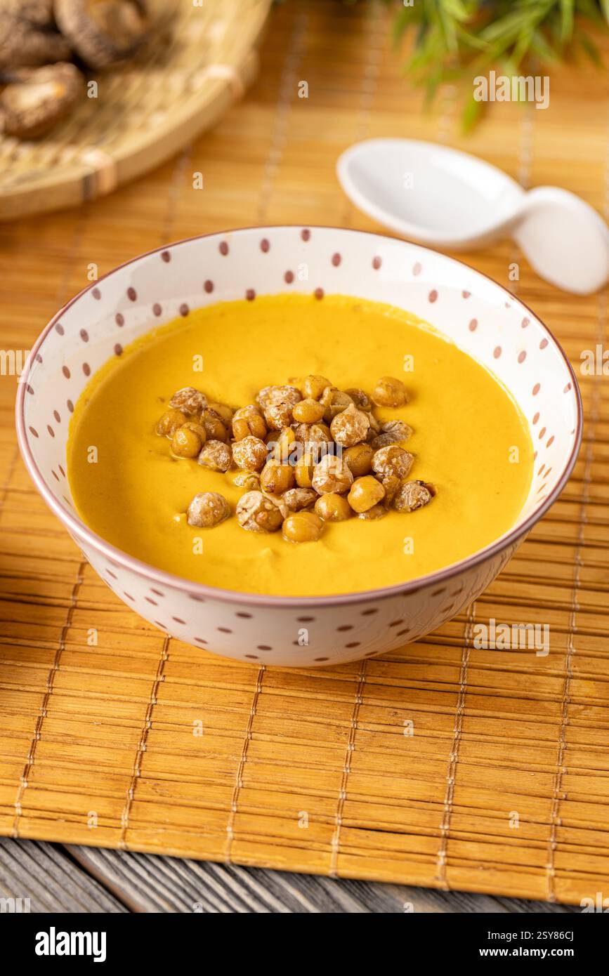 Gros plan sur une délicieuse soupe à la crème de citrouille assaisonnée de pois chiches rôtis Banque D'Images