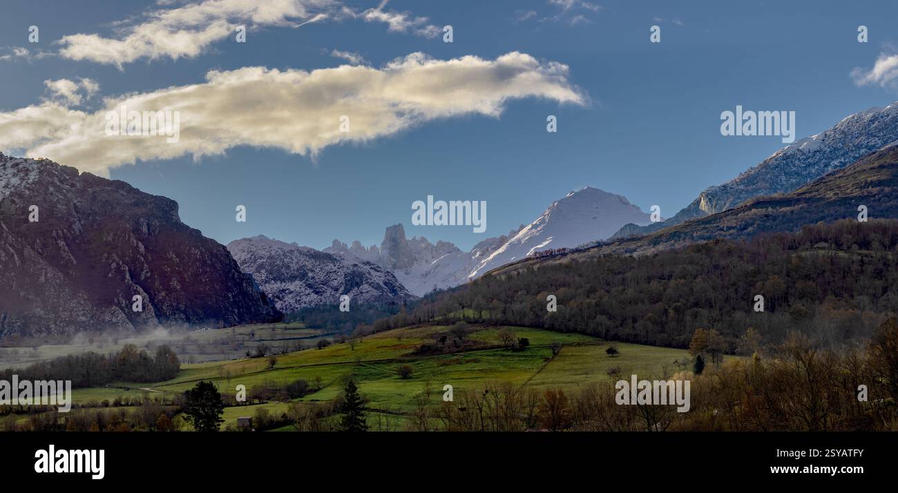 Superbe vue panoramique sur les montagnes, montrant des sommets enneigés et des vallées verdoyantes sous un ciel bleu clair avec des nuages. Banque D'Images
