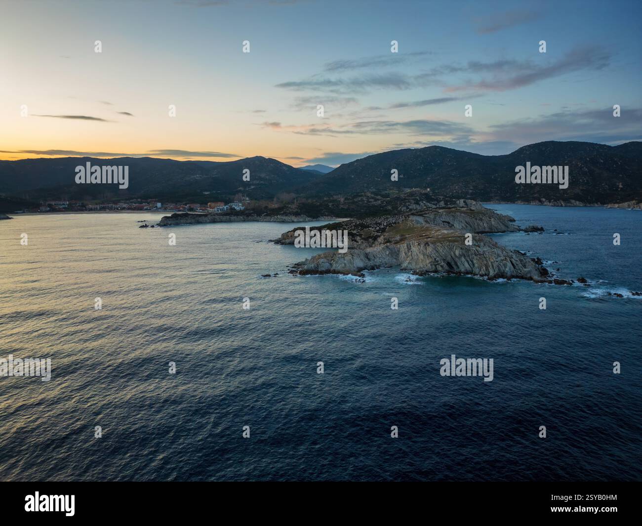 Une vue panoramique sur le village de Kalamitsi et la plage en Grèce au coucher du soleil. La côte accidentée, la mer calme et les collines ondulantes créent un cadre paisible et pittoresque Banque D'Images