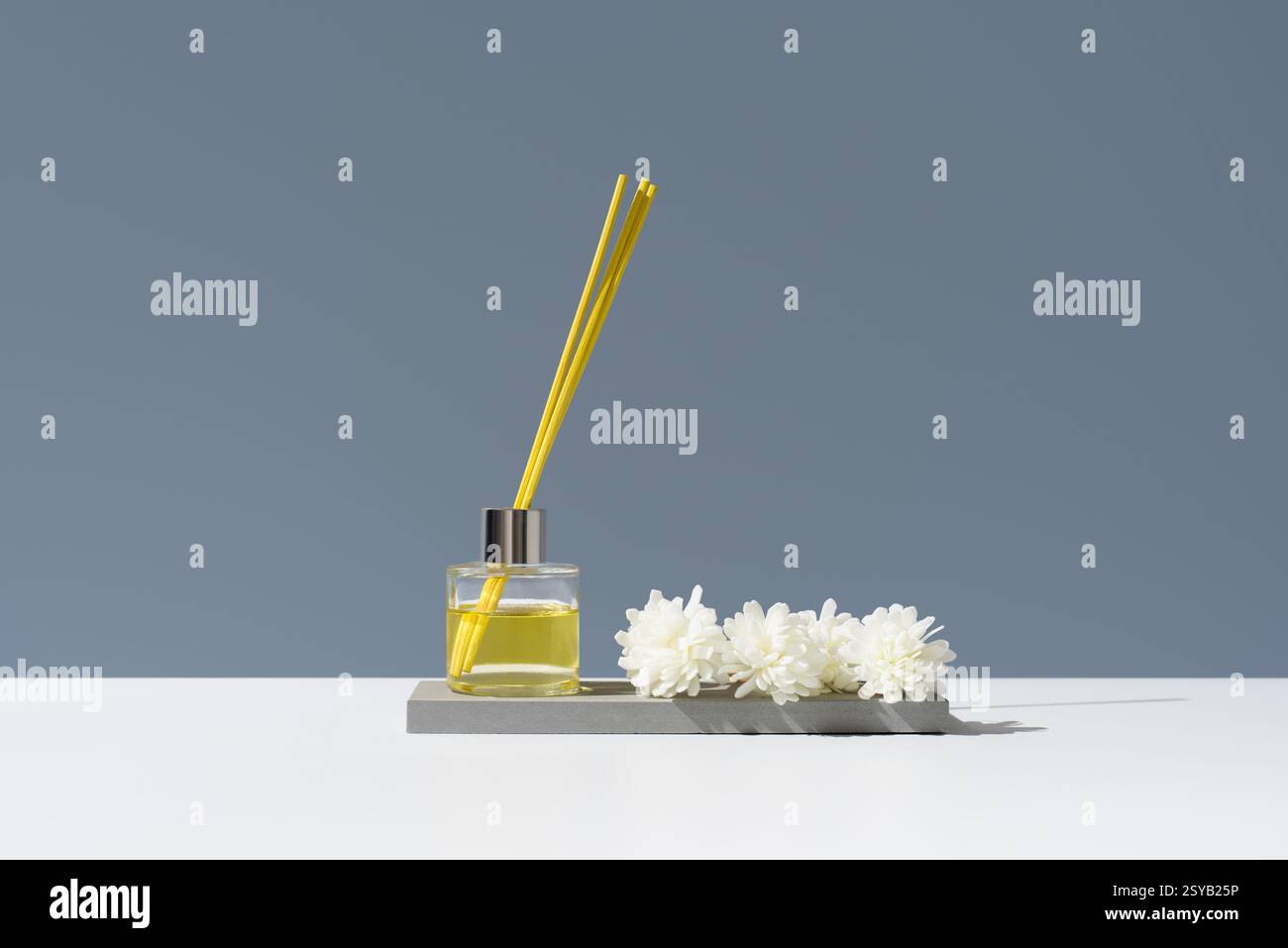 Élégant diffuseur aromatique en verre avec huile essentielle de citron et décor floral, créant une ambiance rafraîchissante. Idéal pour la maison ou le bureau à élever t Banque D'Images