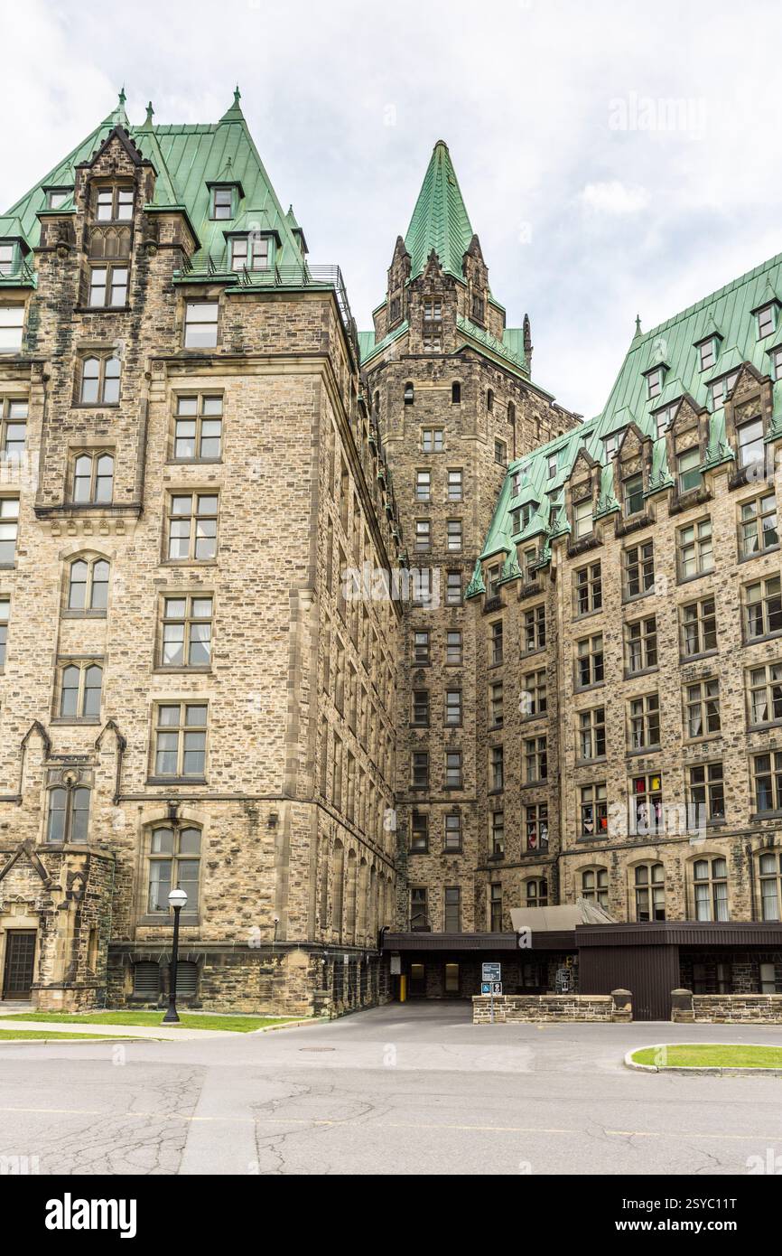 Grand bâtiment avec un toit vert et une tour de l'horloge. Le bâtiment est brun et a un toit vert Banque D'Images