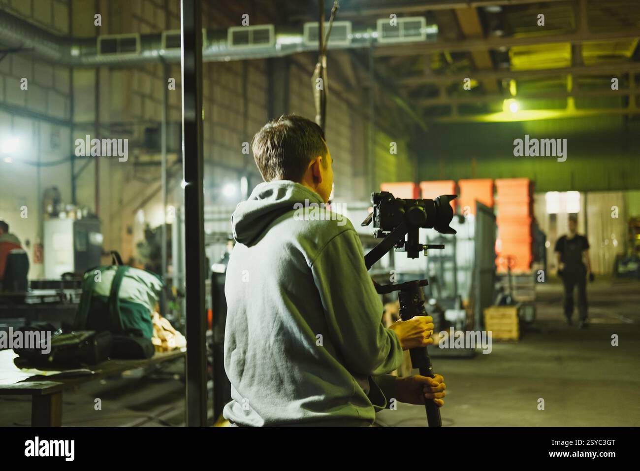 Cinéaste se préparant à tourner dans un cadre industriel spacieux Banque D'Images