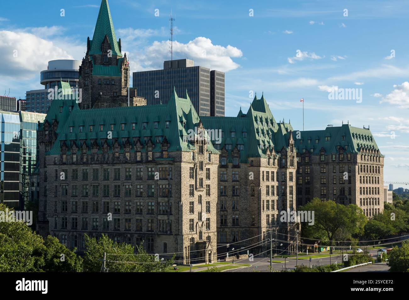 Grand bâtiment avec un toit vert. Le bâtiment est dans une ville. Il y a des arbres devant le bâtiment Banque D'Images