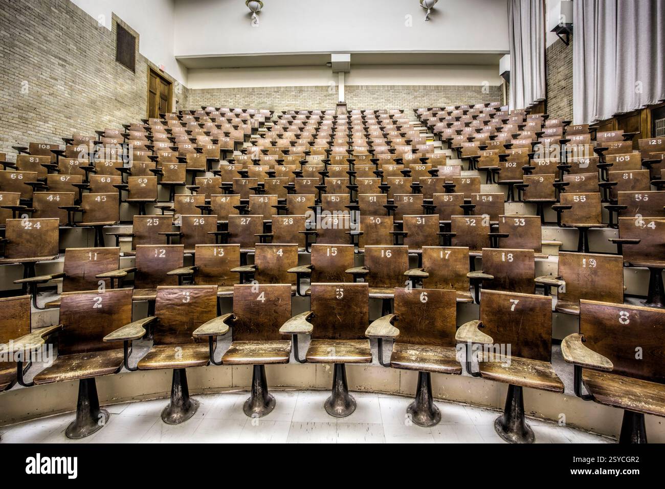 Rangée de chaises en bois dans une salle de classe. Les chaises sont numérotées de 1 à 12 Banque D'Images