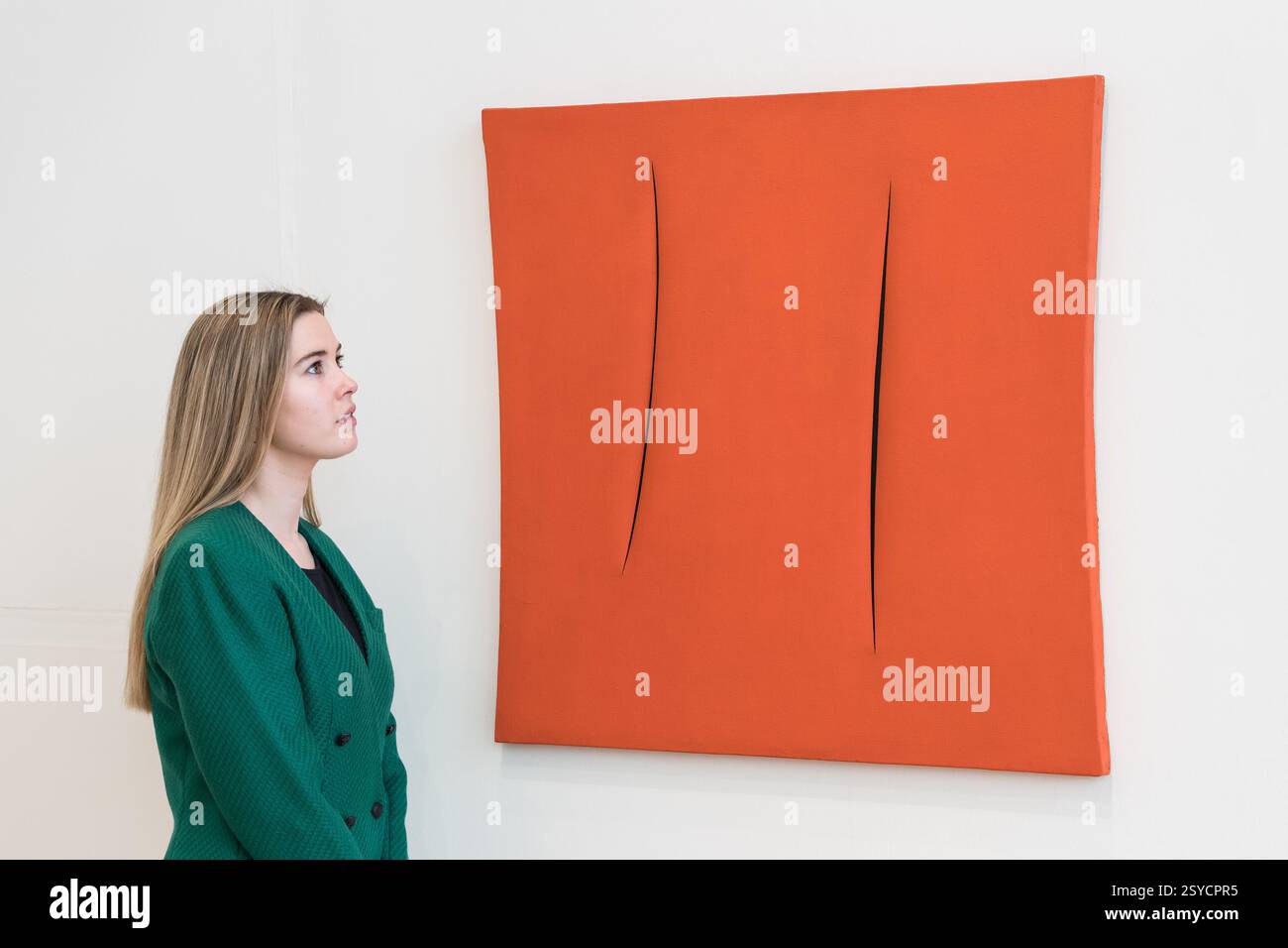 Londres, Royaume-Uni. 28 février 2025. LONDRES, ROYAUME-UNI - 28 FÉVRIER 2025 : un membre du personnel regarde un tableau de Lucio Fontana, “Concetto spaziale, Attese”, estimation : £1 000 000 - 2 000 000 lors d'une visite photo à la maison de vente aux enchères Phillips présentant les points forts des ventes aux enchères d'art moderne et contemporain à Londres, Royaume-Uni, le 28 février 2025. (Photo de Wiktor Szymanowicz/NurPhoto) crédit : NurPhoto SRL/Alamy Live News Banque D'Images
