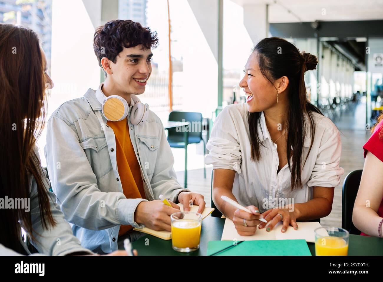 Groupe diversifié d'étudiants universitaires étudiant ensemble à la cafétéria de l'université. Banque D'Images