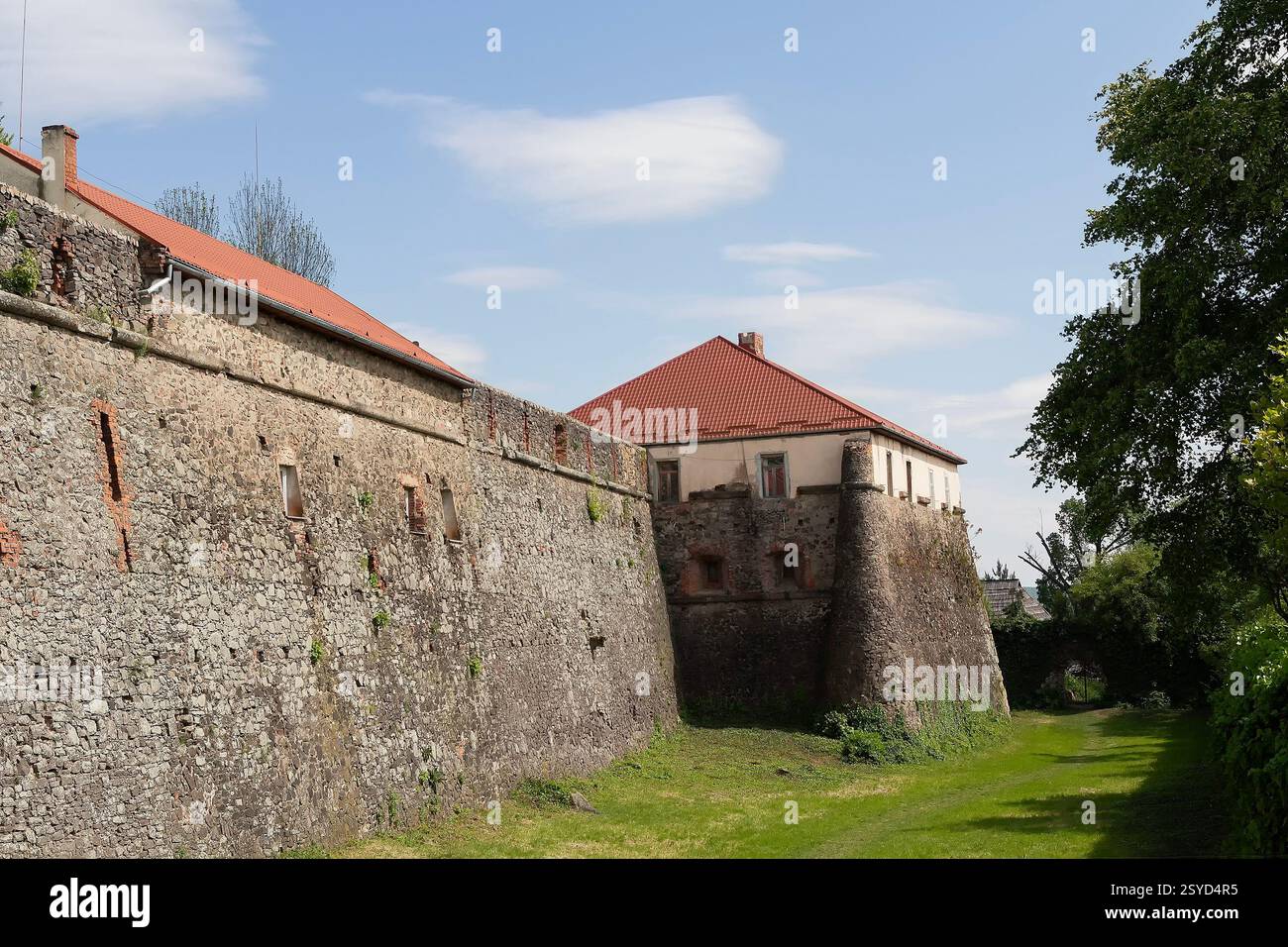 Mur médiéval du château gris de l'ancien château d'Uzhgorod avec une pelouse verte en face. Château d'Uzhgorod. Ukraine, région de Zakarpattya Banque D'Images