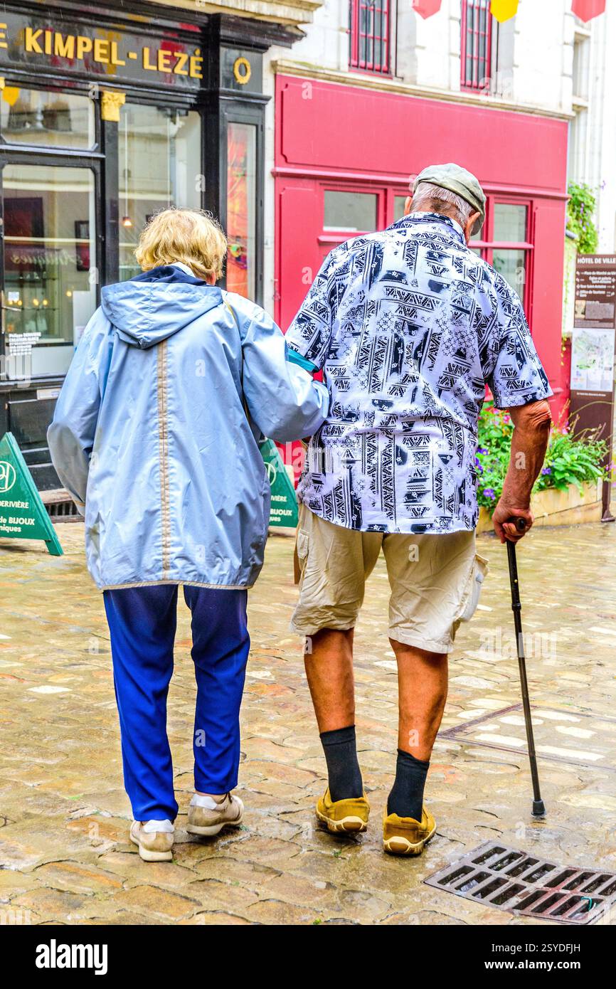 Vue arrière d'un couple âgé marchant bras dans bras, homme avec canne à pied - Loches, Indre-et-Loire (37), France. Banque D'Images