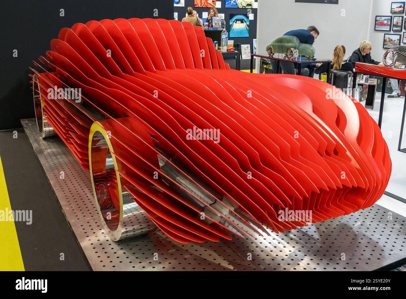 Représentation artistique d'une sculpture de voiture rouge présentant un design innovant lors d'une exposition dans un cadre créatif Banque D'Images