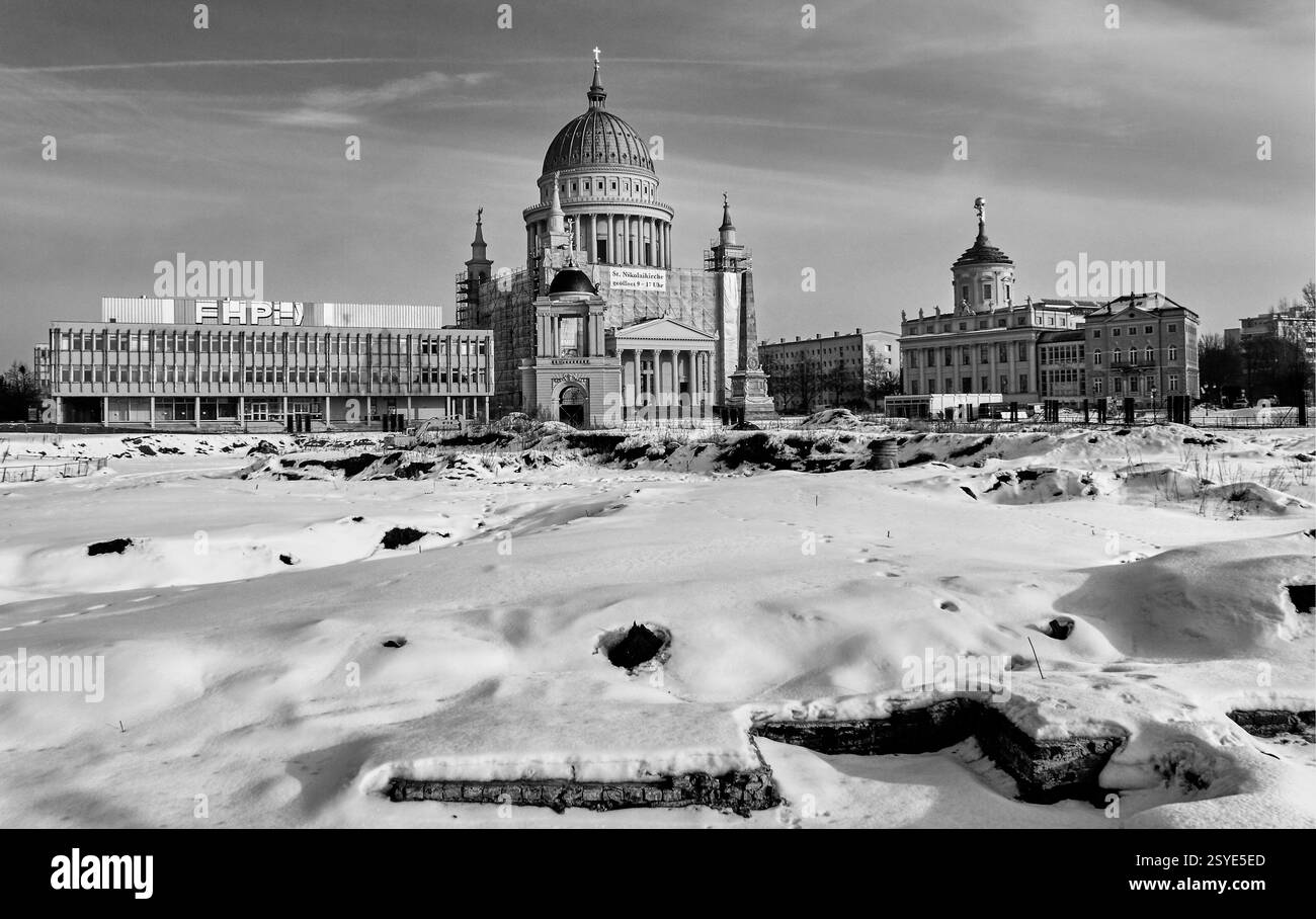 1 000 ans d'histoire - fondations médiévales au premier plan couvertes de neige avec l'église Saint-Nicolas et le bâtiment de l'ère soviétique derrière Banque D'Images