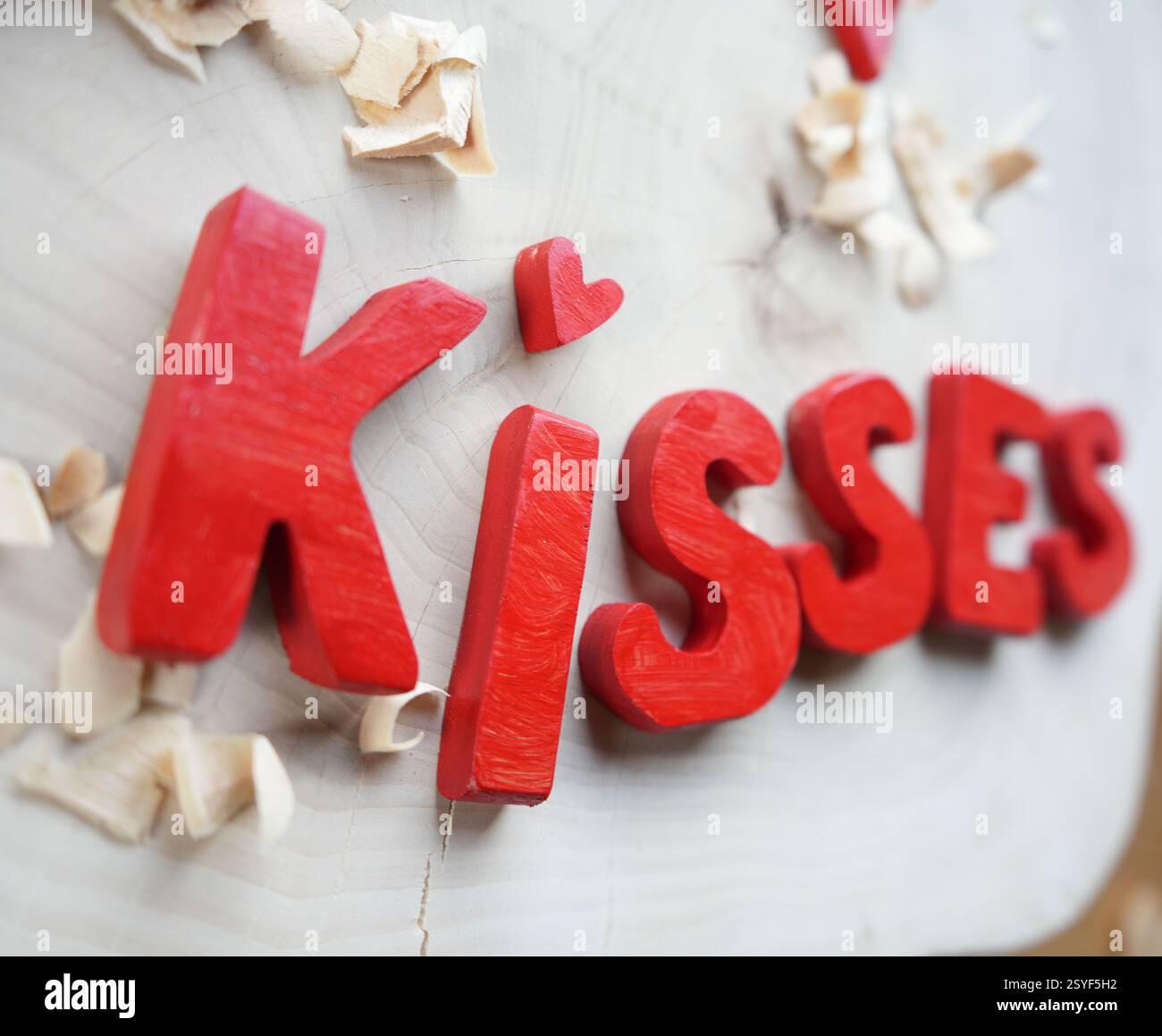 Faits à la main, lettres en bois. célébrer l'amour. Lettres rouges orthographiant le mot Kiss Banque D'Images