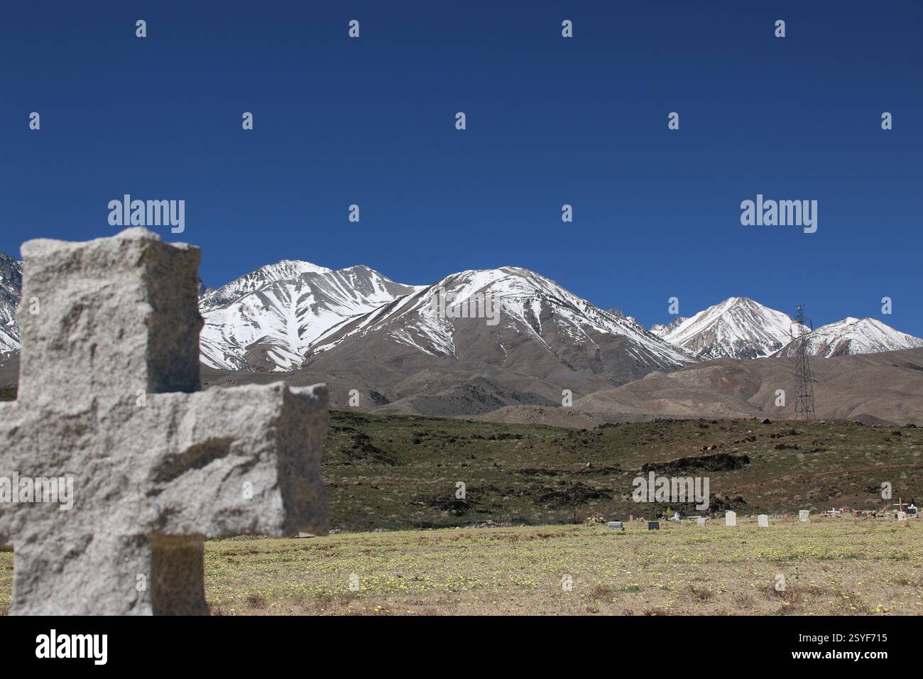 Une croix dans un petit cimetière de la vallée de l'Owens avec vue sur la Sierra Nevada enneigée. Banque D'Images
