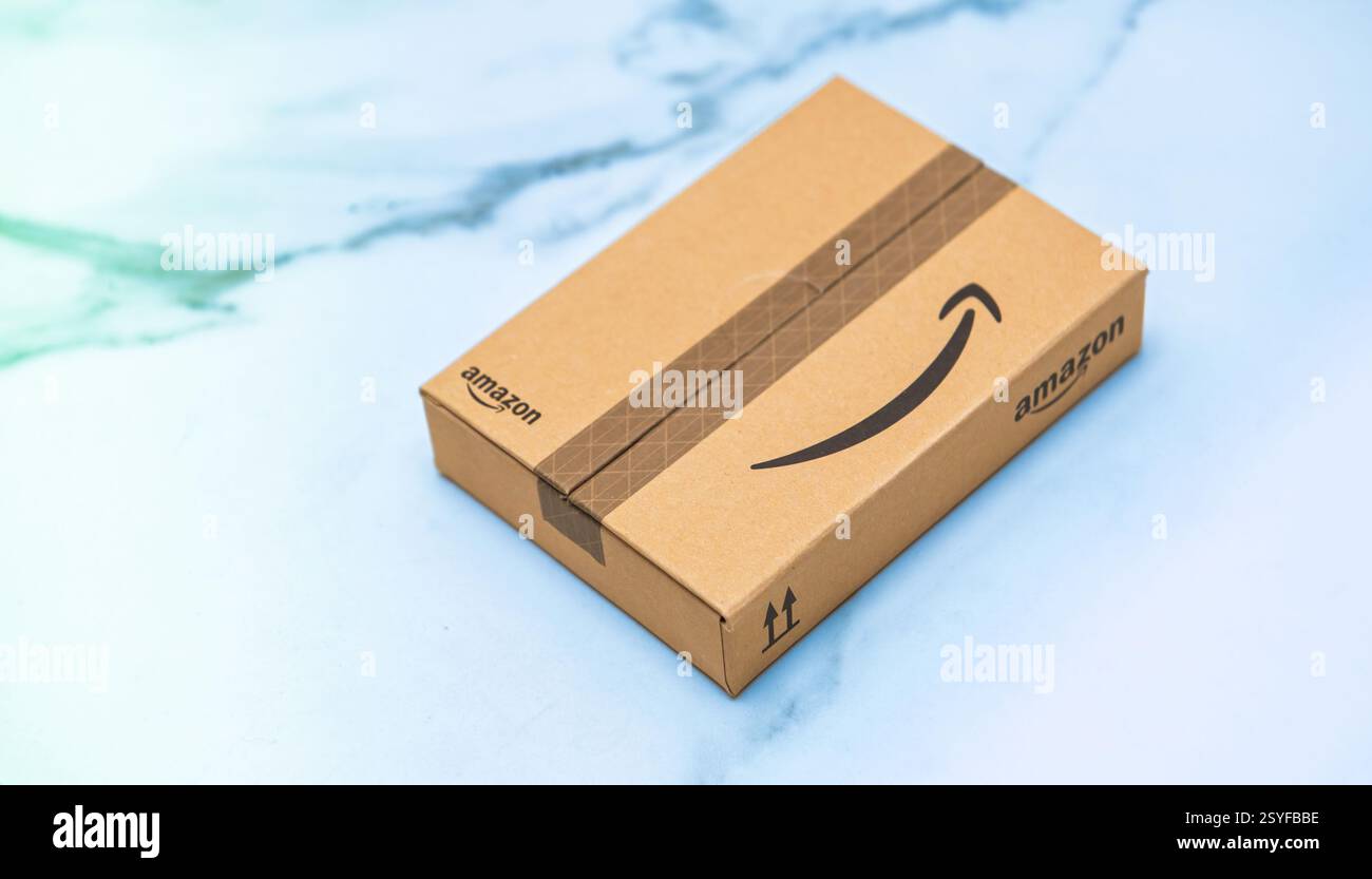 Paris, France - 22 novembre 2022 : un petit paquet Amazon est placé sur une surface lisse et de couleur claire, mettant en vedette le logo Amazon reconnaissable et packagi Banque D'Images