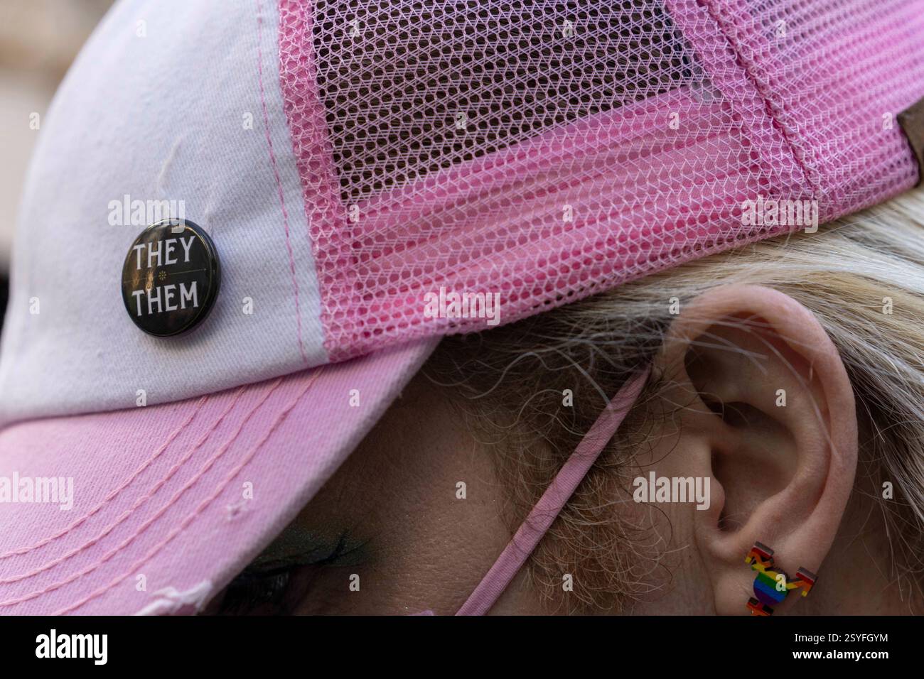 Seattle, Washington, États-Unis. 28 février 2025. Une personne porte un bouton avec des pronoms ''They/They'' sur une casquette de baseball rose alors que le procureur général de l'État de Washington, Nick Brown, parle de son procès en cours devant la cour fédérale concernant les soins d'affirmation de genre devant la cour de district des États-Unis à Seattle, Washington, États-Unis, le Fri., février 28, 2025. L'État sollicite une injonction préliminaire contre le décret du président Donald Trump interdisant les soins prodigués aux jeunes pour affirmer leur sexe. Le tribunal n'a pas immédiatement rendu de décision. (Crédit image : © Scott Brauer/ZUMA Press Wire) USAGE ÉDITORIAL SEULEMENT! Pas pour Commerc Banque D'Images