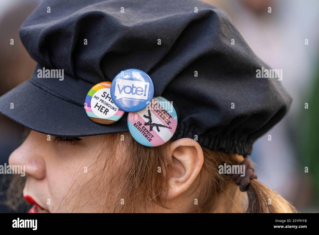 Seattle, Washington, États-Unis. 28 février 2025. Une personne porte un bouton avec des pronoms ''elle'' et des drapeaux de fierté alors que le procureur général de l'État de Washington, Nick Brown, parle de son procès en cours devant la Cour fédérale concernant les soins d'affirmation de genre devant la Cour de district des États-Unis à Seattle, Washington, USA, le Fri., février 28, 2025. L'État sollicite une injonction préliminaire contre le décret du président Donald Trump interdisant les soins prodigués aux jeunes pour affirmer leur sexe. Le tribunal n'a pas immédiatement rendu de décision. (Crédit image : © Scott Brauer/ZUMA Press Wire) USAGE ÉDITORIAL SEULEMENT! Non destiné à UN USAGE commercial Banque D'Images