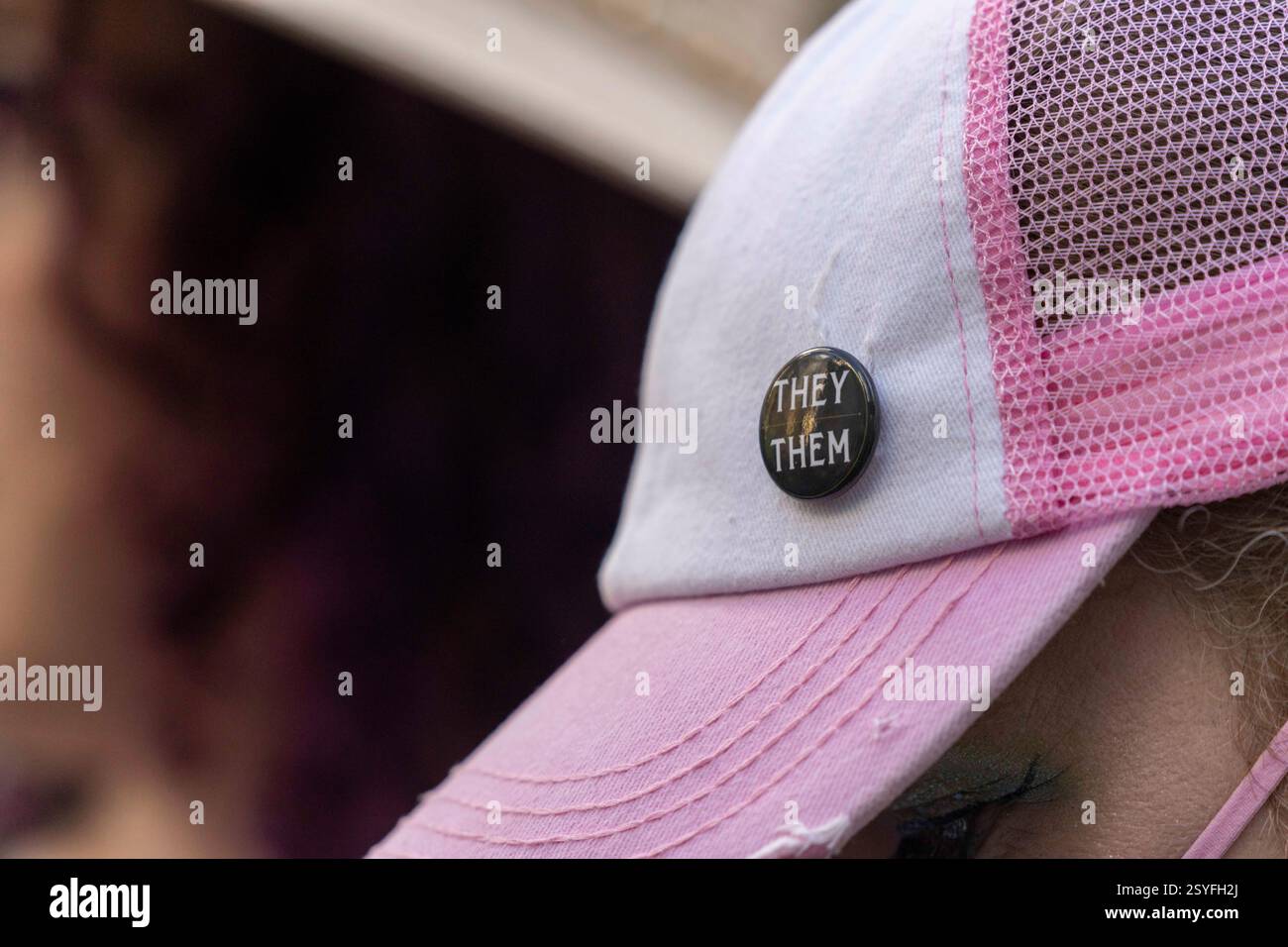 Seattle, Washington, États-Unis. 28 février 2025. Une personne porte un bouton avec des pronoms ''They/They'' sur une casquette de baseball rose alors que le procureur général de l'État de Washington, Nick Brown, parle de son procès en cours devant la cour fédérale concernant les soins d'affirmation de genre devant la cour de district des États-Unis à Seattle, Washington, États-Unis, le Fri., février 28, 2025. L'État sollicite une injonction préliminaire contre le décret du président Donald Trump interdisant les soins prodigués aux jeunes pour affirmer leur sexe. Le tribunal n'a pas immédiatement rendu de décision. (Crédit image : © Scott Brauer/ZUMA Press Wire) USAGE ÉDITORIAL SEULEMENT! Pas pour Commerc Banque D'Images