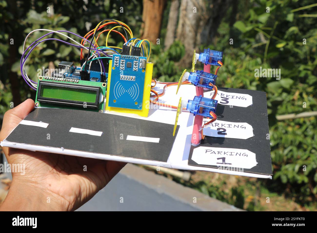 Modèle de fonctionnement d'un système de stationnement intelligent basé sur RFID qui utilise un microcontrôleur programmable et un servo pour son fonctionnement tenu dans la main Banque D'Images