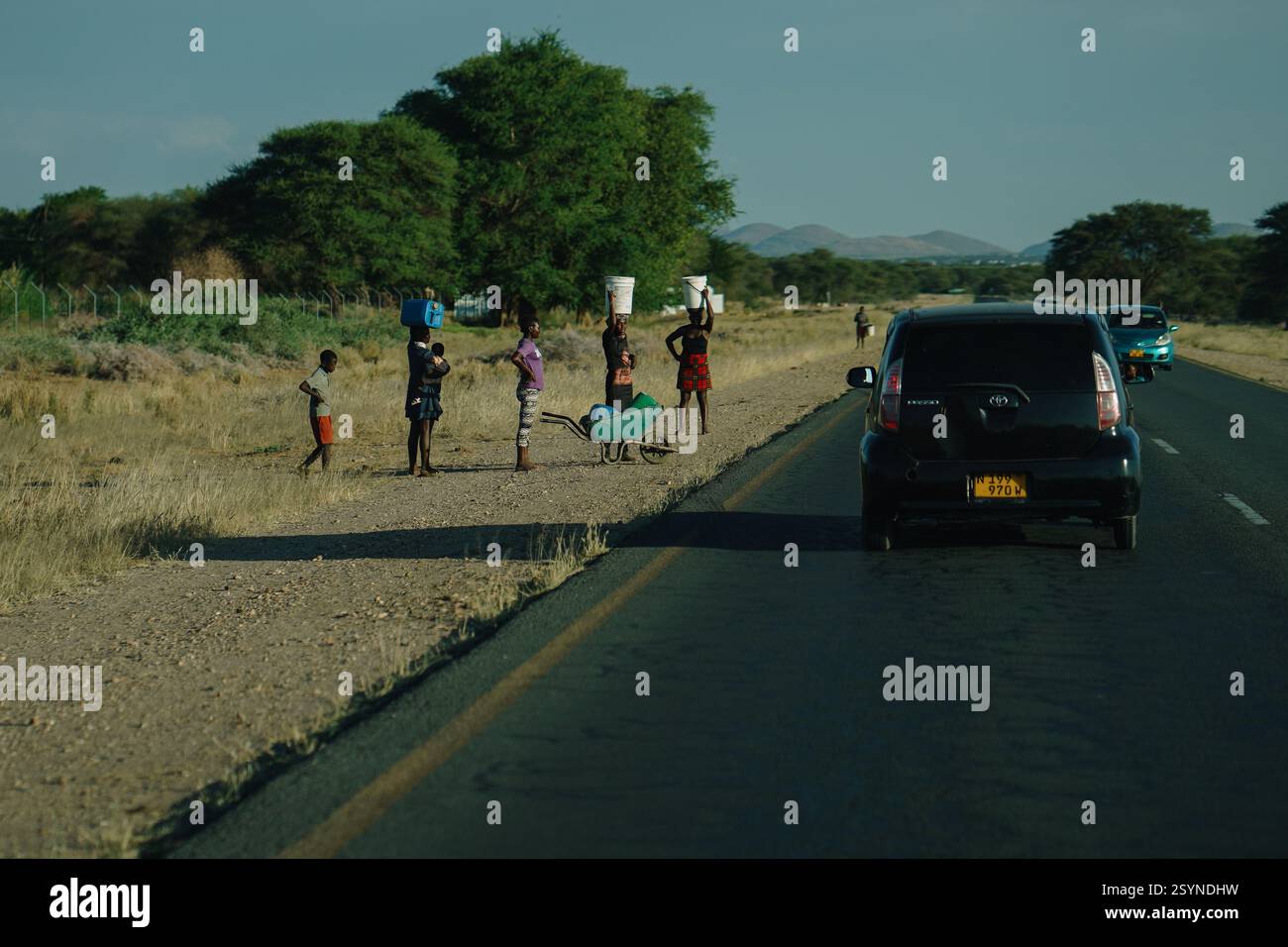 Windhoek, Namibie - 29 avril 2024. Des femmes et des enfants sur le bord de la route en attente de transport de passage en Namibie, Afrique. Banque D'Images