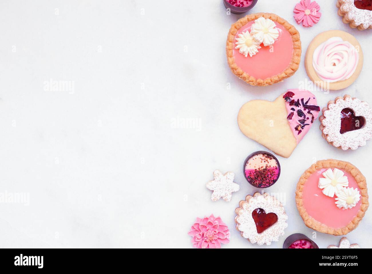 Fête des mères ou bordure de cuisson sur le thème de l'amour avec divers biscuits et gâteries sucrées. Vue aérienne sur un fond de bannière en marbre blanc avec espace de copie Banque D'Images