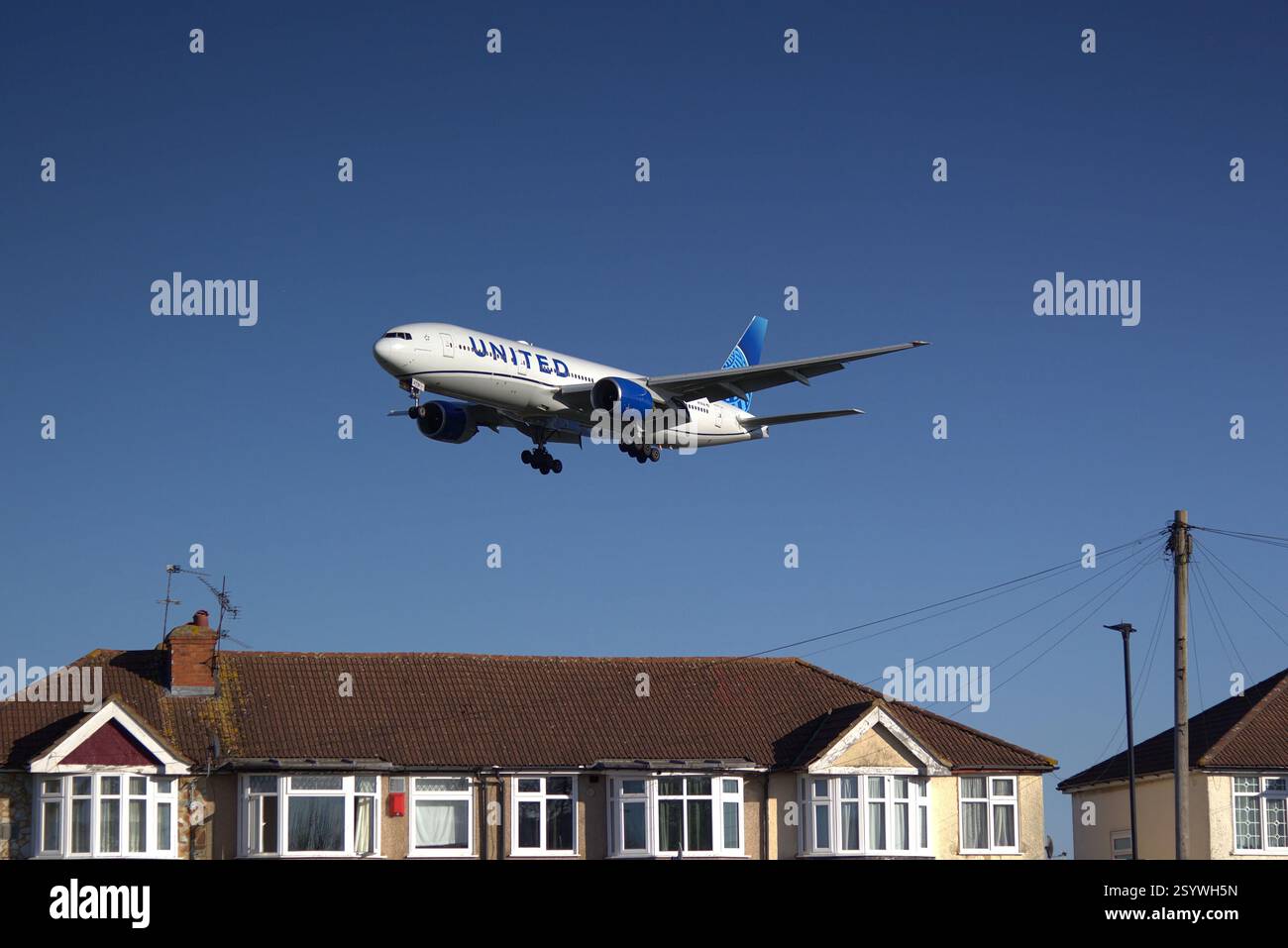 United Airlines Boeing 777-222 er N791UA, survole Myrtle Avenue, Hounslow, en approche finale avant d'atterrir à l'aéroport d'Heathrow. Banque D'Images