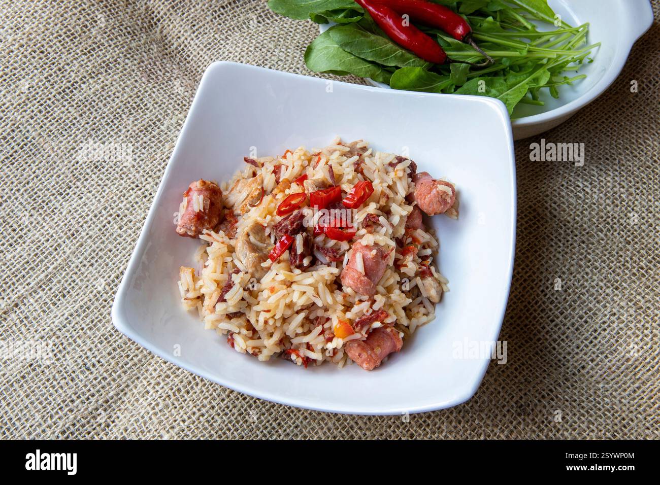 Arroz de Carreteiro - cuisine typique du sud du Brésil, préparée avec du riz, de la viande séchée, de la saucisse pepperoni, de la longe de porc et du bacon sur une nappe de jute Banque D'Images