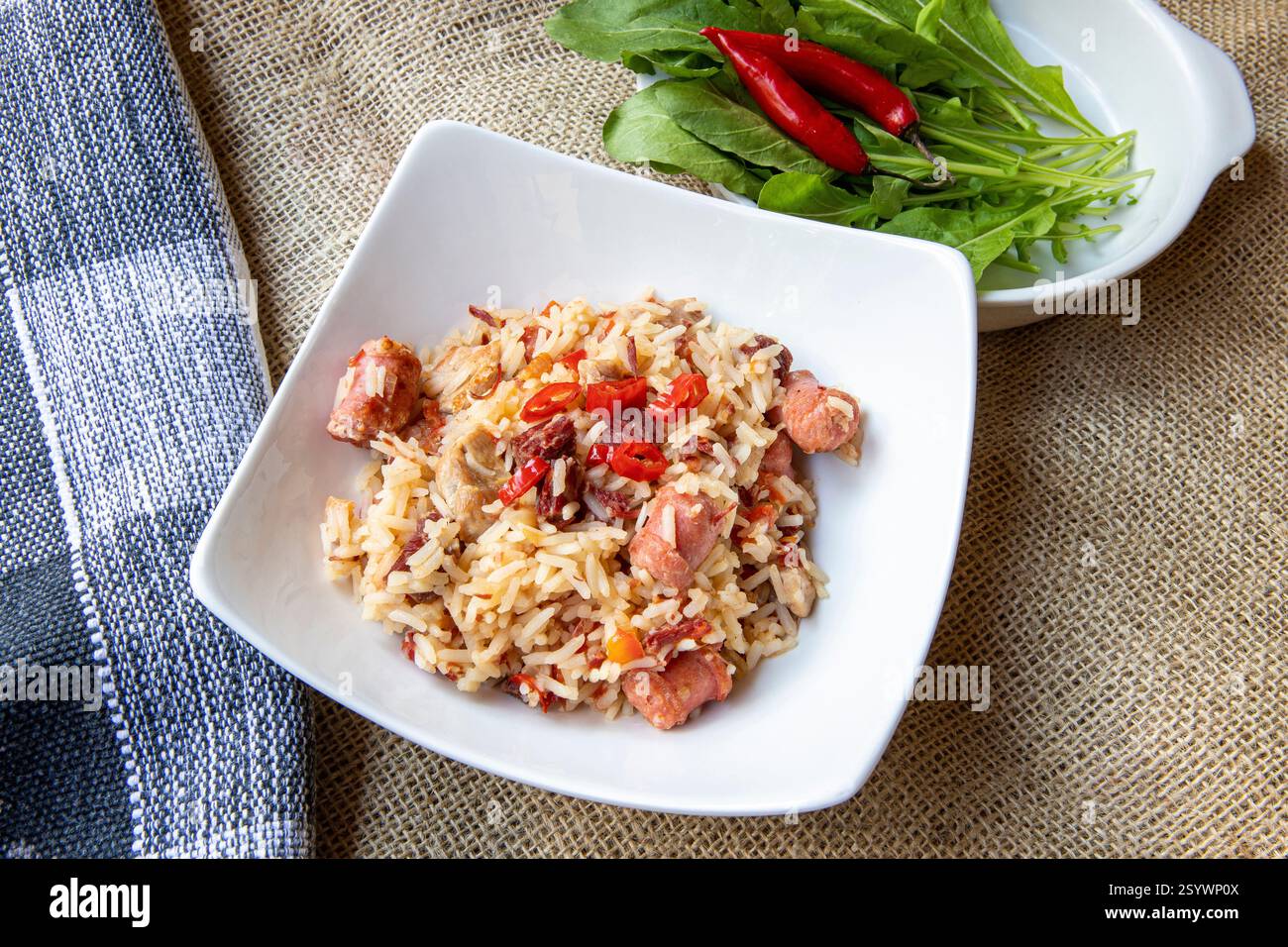 Arroz de Carreteiro - cuisine typique du sud du Brésil, préparée avec du riz, de la viande séchée, de la saucisse pepperoni, de la longe de porc et du bacon sur une nappe de jute Banque D'Images